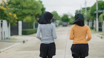 Zwei muslimische Mädchen im Teenageralter haben Spaß beim Joggen. Abends in ihrem Dorf video