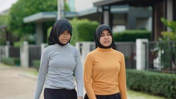 dos adolescentes musulmanas se divierten haciendo jogging. en su pueblo por la noche video