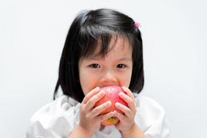 Child are hungry for eating apples. Children eat fruit to add vitamins to the body. photo