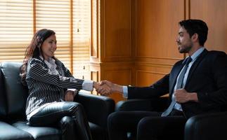 picture of businessman and businesswoman handshaking after making deal in office photo