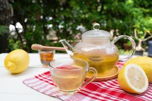 Té de la tarde caliente con miel y limón servido en la mesa del café foto