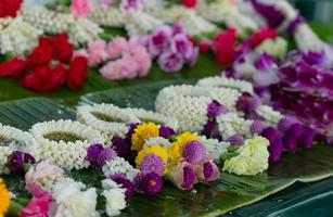 Hermosa guirnalda de flores de estilo tradicional tailandés hecha de muchos tipos de flores para la venta en el mercado de productos frescos foto
