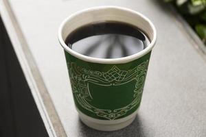 Black coffee in a green paper cup like Mc Donalds. photo