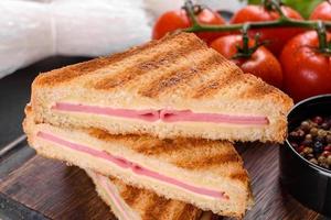 Sandwich with ham, cheese, tomatoes, lettuce, and toasted bread photo