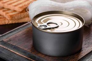 Canned delicious fresh tuna in oil with salt and spices in a tin can photo