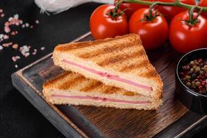 Sandwich with ham, cheese, tomatoes, lettuce, and toasted bread photo