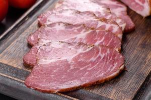 Delicious fresh bacon sliced with bread and vegetables photo
