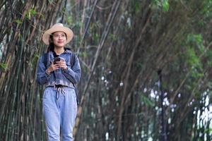 Young Asian woman explores the forest on holiday photo