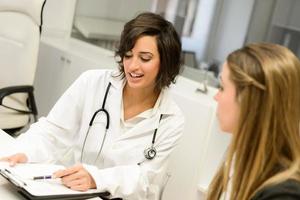 Doctor explaining diagnosis to her female patient photo