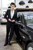 Young handsome man, model of fashion, with luxury cars photo