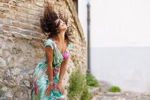 Beautiful brunette middle-aged woman wearing spring colorful dress outdoors photo