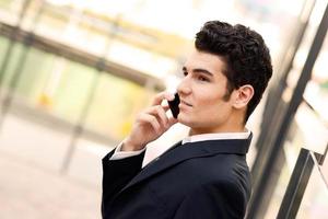 Young businessman in an office building talking on the phone photo