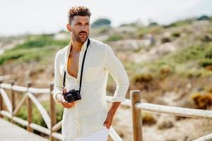 Handsome man photographing in a coastal area. photo