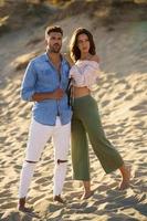 Young couple standing on the sand of the beach photo