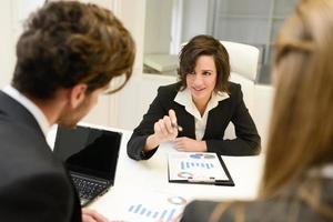 Business partners discussing documents and ideas at meeting photo