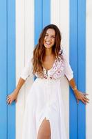 Young woman, fashion model, posing in front of a beach booth. photo