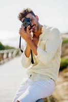 Handsome man photographing in a coastal area. photo