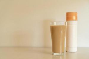 Vaso de café con leche con botellas de café listas para beber foto