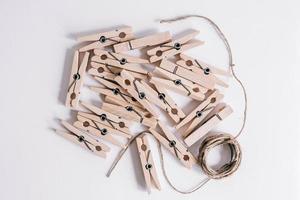 Wooden clothespins with rope on white background. View from above. Copy space photo