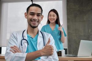 equipo de socios de atención médica, retrato de dos jóvenes médicos de origen asiático en uniforme con estetoscopio, sonriendo y mirando a cámara en la clínica, personas con experiencia en tratamiento profesional. foto