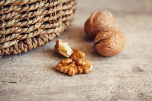 Walnuts in a round wicker basket on a wooden background. Place for your text photo