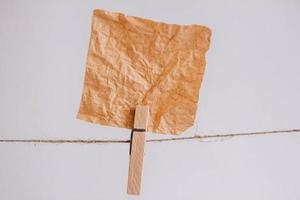 Brown stickers on clothesline with wooden clothespin isolated on white background. Place for your text photo