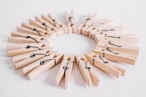 Group of wooden clothespins arranged in a circle isolated on white background. Copy space photo