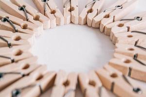 Group of wooden clothespins arranged in a circle isolated on white background. Copy space photo