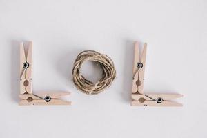 Wooden clothespins with rope on white background. View from above. Copy space photo