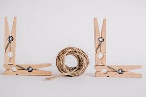 Wooden clothespins with rope on white background. Place for your text photo