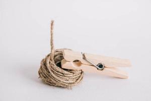 Wooden clothespin with rope on white background. Place for your text photo