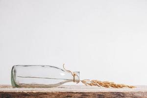 Still life of a bouquet of dried flowers in a glass bottle on a wooden table. Place for text or advertising photo