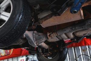 The undercarriage of a car with a jack is lifted for repairs. photo