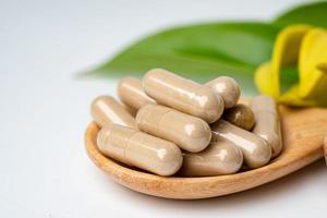 Medicina alternativa cápsula orgánica a base de hierbas, mineral, medicamento con hojas de hierbas, suplementos naturales para una vida sana y buena. foto