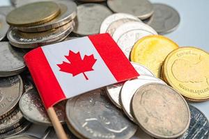 Pila de monedas con la bandera de Canadá sobre fondo blanco. foto