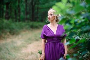 Girl model blonde in a lilac dress with a bouquet photo