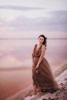 girl on the shore of a pink salt lake