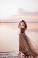 girl on the shore of a pink salt lake photo