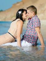 a guy and a girl walk along the seashore photo