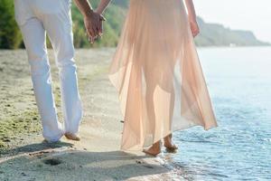 a guy and a girl walk along the seashore photo