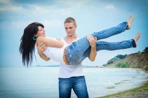 chico y una chica en jeans y camisetas blancas en la playa foto