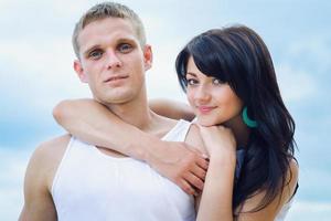 guy and a girl in jeans and white t-shirts on the beach photo