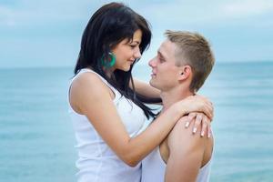 guy and a girl in jeans and white t-shirts on the beach photo