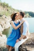 a young couple a guy and a girl are walking near a mountain lake surrounded photo