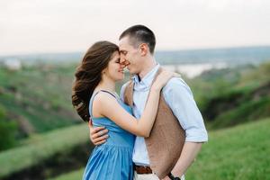 pareja joven, un chico y una chica están caminando en las colinas de la montaña foto