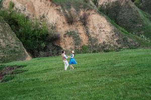 pareja joven, un chico y una chica están caminando en las colinas de la montaña foto