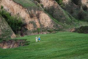 young couple a guy and a girl are walking in the mountain hills photo