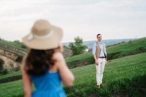 pareja joven, un chico y una chica están caminando en las colinas de la montaña foto