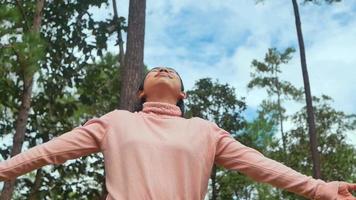 mujer feliz caminando en el parque y disfrutando de la naturaleza en primavera. video