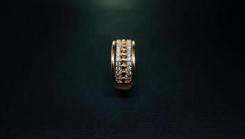 Photo of womens gold ring on a black background